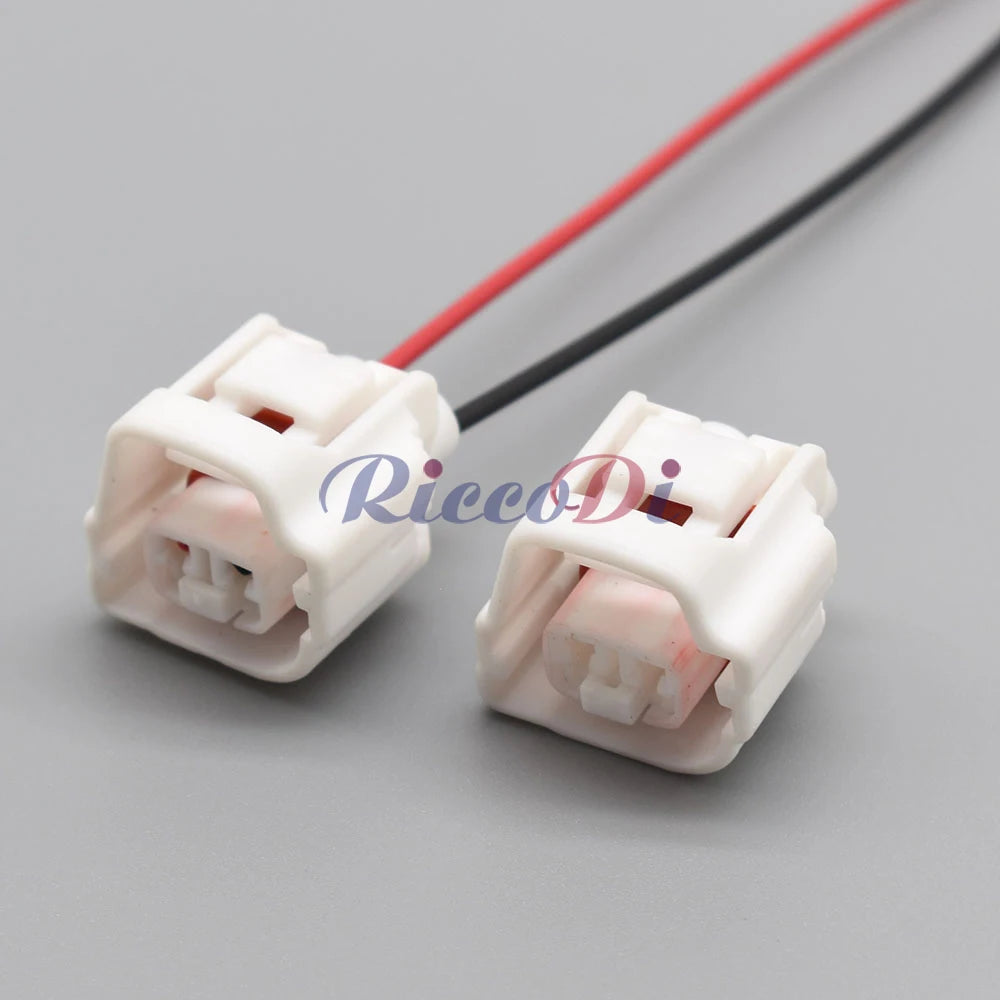 Close-up of 2-pin white car connector showing male and female contacts for reliable electrical connections