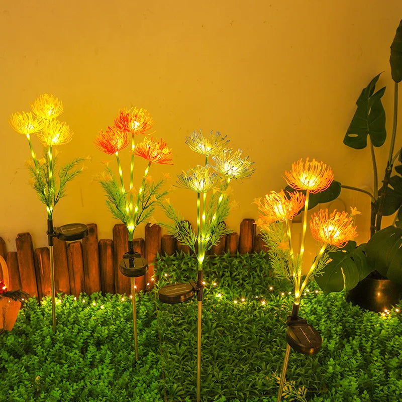 Close-up of solar LED lily lights with 3 glowing flower heads for outdoor garden and yard decoration